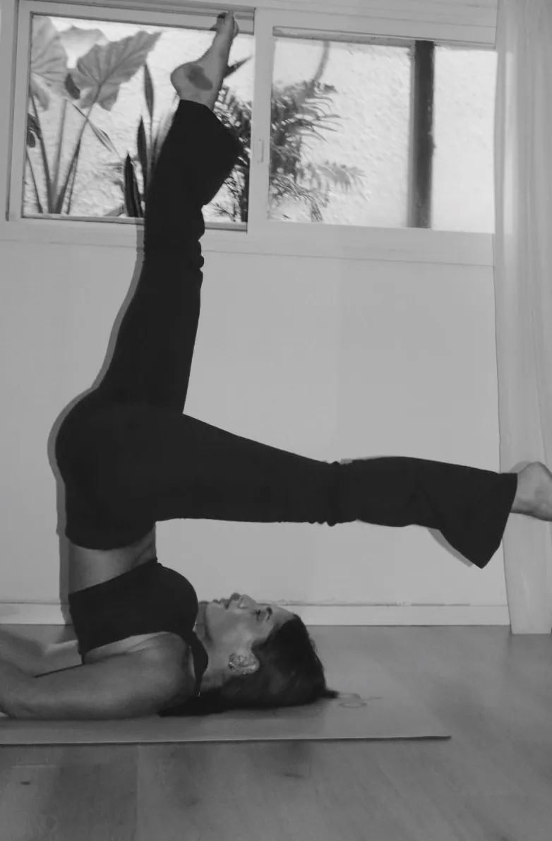 Mika holding a shoulder stand on the mat